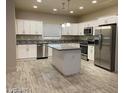 Modern kitchen with stainless steel appliances, white cabinets, gray countertop, and a center island at 31 White Burch Ln, Pahrump, NV 89048