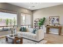 Bright living room featuring large windows, plush seating, stylish decor, and wood-look flooring at 3218 Squire St, Las Vegas, NV 89135