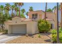 Home featuring a two-car garage, complemented by mature trees at 5228 Painted Lakes Way, Las Vegas, NV 89149