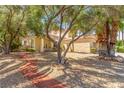 Home surrounded by lush trees and landscape design at 5228 Painted Lakes Way, Las Vegas, NV 89149