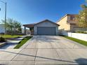 Charming single-story home featuring a two-car garage and a well manicured lawn at 6292 Yucca Valley Ct, Las Vegas, NV 89142