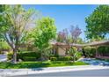 Inviting single story home with lush landscaping, mature trees, and a cozy front yard at 63 Feather Sound Dr, Henderson, NV 89052