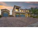 Elegant two-story home featuring a three-car garage, a balcony, a stone facade, and a spacious paved driveway at 8528 Baltimore Heights Ct, Las Vegas, NV 89113
