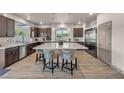 Beautiful kitchen featuring dark wood cabinets, stainless steel appliances, and a large white island with seating at 8528 Baltimore Heights Ct, Las Vegas, NV 89113