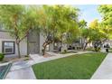 A modern gray home with a healthy green lawn, trees, and a sidewalk leading to the front door at 9050 W Tropicana Ave # 1017, Las Vegas, NV 89147