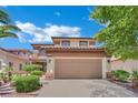 Exterior view of a two-story home showcasing the two-car garage and desert landscaping at 96 Saint Johns Wood Ave, Henderson, NV 89002