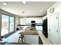 Bright kitchen showcasing a center island with granite counters, black appliances, and sliding door access to the backyard at , Las Vegas, NV 89179