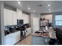 Spacious kitchen with modern white cabinets, stainless steel appliances, granite countertops, and a center island with seating at 10163 Kings Amethyst St, Las Vegas, NV 89141