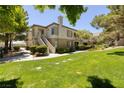 Beautiful exterior of the property showcasing lush green grass and mature trees at 1705 King James St # 203, Las Vegas, NV 89144
