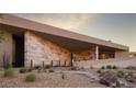 Home with stone accent wall, modern desert landscaping, and unique entrance at 21 Rockstream Dr, Henderson, NV 89012