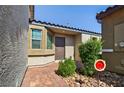 Inviting front entrance with a brick walkway, a neutral-toned exterior, and charming desert landscaping at 2175 Limestone Cove Ct, Laughlin, NV 89029