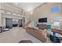 Bright, open-concept living room with soaring ceilings, stylish flooring, and a view of the upper level at 2637 Ohio Ct, Las Vegas, NV 89128