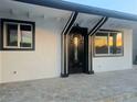Stunning front entrance with a decorative black door, contrasting trim and ample natural light from surrounding windows at 3215 Dillon Ave, North Las Vegas, NV 89030
