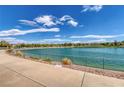 Scenic view of a community lake with clear blue water, walking paths, and surrounding landscaping in a suburban neighborhood at 412 Gracious Way, Henderson, NV 89011