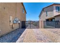 Gated backyard access with a gravel and brick-paved pathway leading to the rear of the property at 4206 Topaz Hills Dr, North Las Vegas, NV 89032