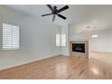 Bright living room features wood-look flooring, a ceiling fan, and a cozy fireplace at 6533 Sundown Heights Ave, Las Vegas, NV 89130