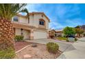 Charming two-story home with a well-manicured front yard and an attached two-car garage at 775 Wigan Pier Dr, Henderson, NV 89002