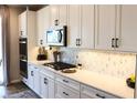 Modern kitchen with white cabinets, stainless steel appliances, and marble hexagon backsplash at 8186 Guadiano Ave, Las Vegas, NV 89113
