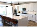 Bright kitchen with white cabinetry, stainless appliances, an island, and a sliding glass door to the outdoor patio at 8186 Guadiano Ave, Las Vegas, NV 89113