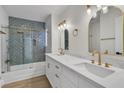 Elegant bathroom showcasing a double vanity, quartz countertops, and a glass-enclosed shower and tub at 8416 Kawala Dr, Las Vegas, NV 89128