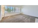 Empty living room with a large window featuring plantation shutters, and carpet flooring at 9717 Buckhorn Dr, Las Vegas, NV 89134