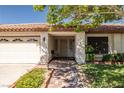 Inviting single-story home with well-kept landscaping, a tile roof, and a charming walkway to the front door at 2821 Whispering Wind Dr, Las Vegas, NV 89117