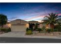 Inviting single-story home featuring a well-manicured lawn, desert landscaping, and an attached two-car garage at 10400 Premia Pl, Las Vegas, NV 89135