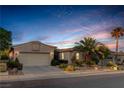 Inviting single-story home featuring a well-manicured lawn, desert landscaping, and an attached two-car garage at 10400 Premia Pl, Las Vegas, NV 89135