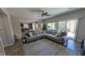 Open-concept living room with a large sectional sofa, neutral colors, and ample natural light at 10668 Berkshire Woods Ave, Las Vegas, NV 89166