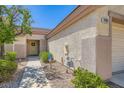 Inviting front entrance with a charming wreath, manicured landscaping, and well-lit pathway at 2085 Joy View Ln, Henderson, NV 89012