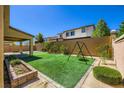Well manicured backyard featuring artificial turf, playground set, and privacy fence at 397 Pearl Fountains Ct, Las Vegas, NV 89148