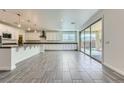 Large open kitchen with a center island, stainless steel appliances, pendant lighting, and sliding door access to the backyard at 397 Pearl Fountains Ct, Las Vegas, NV 89148