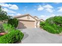 Inviting single-story residence with a two-car garage and lush, green shrubbery at 412 Carlton Kay Pl, Las Vegas, NV 89144