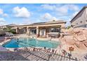 Refreshing backyard pool with a rock waterfall feature and a covered patio at 517 Chance Cove Dr, Henderson, NV 89052