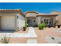 Single-story home featuring desert landscaping, a two-car garage, and a charming front porch at 6100 Cocktail Dr, Las Vegas, NV 89130