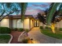 Beautiful home with a landscaped walkway leading to a double door entrance, complemented by lush greenery and desert landscaping at 8650 W Verde Way, Las Vegas, NV 89149