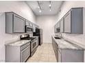 Galley kitchen featuring gray cabinets, granite countertops, and stainless steel appliances at 8805 Jeffreys St # 1048, Las Vegas, NV 89123