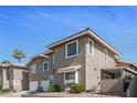Attractive exterior displaying a townhome featuring a well-maintained facade, a two-car garage and desert landscaping at 9270 Apache Springs Dr, Las Vegas, NV 89117