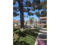 View of a condo complex featuring lush landscaping with tropical palm trees surrounding the community in a vibrant setting at 101 Luna Way # 104, Las Vegas, NV 89145