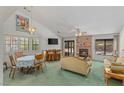 Cozy living room with vaulted ceilings, a brick fireplace, and large windows for natural light at 1590 Desertaire Way, Las Vegas, NV 89110