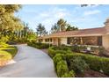 Charming single-story home with lush landscaping, a curved driveway, and a red tile roof at 200 Stonewood Ct, Las Vegas, NV 89107