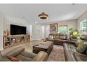 Spacious living room with modern furniture, wooden floors, and a stylish ceiling fan, offering comfortable living space at 2084 Airy Petals Walk, Henderson, NV 89044