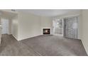Cozy living room featuring a fireplace, neutral carpet, and sliding glass doors for natural light at 3182 Tarpon Dr # 204, Las Vegas, NV 89120