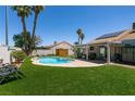 Backyard oasis with a refreshing pool, covered patio, lush lawn, and mature trees at 5025 Chambliss Dr, Las Vegas, NV 89130