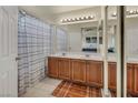 Bathroom featuring double sinks with a large mirror, and a bathtub with shower curtain at 8421 Cheerful Brook Ave, Las Vegas, NV 89143