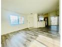 A spacious living room featuring wood-look floors leads to the front door and a view of the kitchen at 1881 W Alexander Rd # 2117, North Las Vegas, NV 89032