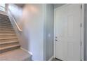 Bright entryway featuring a staircase with carpeted steps and a white front door at 2300 Sky Island Dr, Henderson, NV 89002