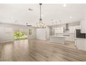 Open-concept living area with hardwood floors, designer lighting, and access to the kitchen at 3391 Stone View Ave, Henderson, NV 89044