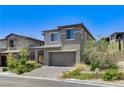 Contemporary two-story home with a two-car garage, desert landscaping, and a paved driveway at 689 Rogue Wave St, Las Vegas, NV 89138