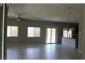 Spacious living room with tile floors, ceiling fan, and sliding glass door to the backyard at 9065 Mastodon Ave, Las Vegas, NV 89149